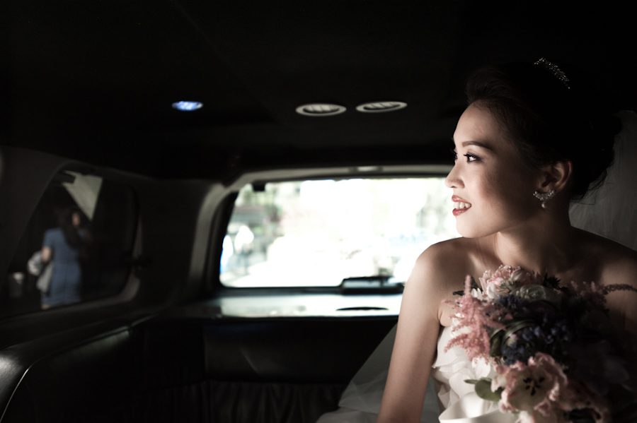 Bride Hae Yoon looking out of the limo on her wedding day at Snug Harbor. Captured by awesome New York City wedding photographer Ben Lau.