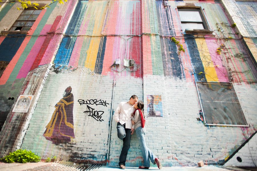 Lisa and Kai lean against a rainbow wall during their engagement session in Williamsburg with awesome NYC wedding photographer Ben Lau.