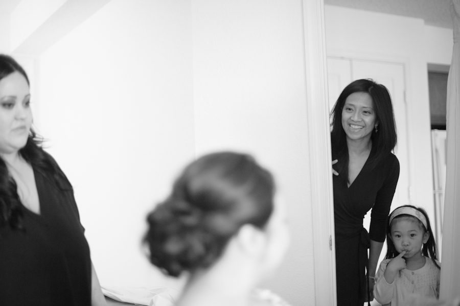 Friend peeks in as bride gets ready for her Washington DC wedding. Captured by Ben Lau Photography.