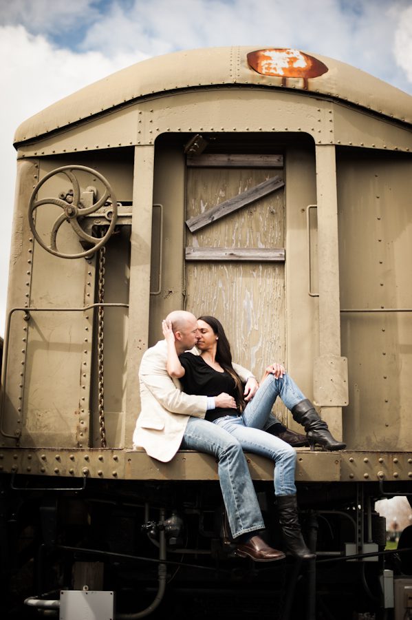 Patrice and Josh sit on a back of a train during their engagement session in Jersey City with northern NJ wedding photographer Ben Lau.