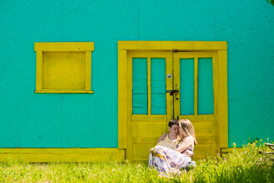 Alexis and Mike sit outside a green wall with yellow door in Long Beach Island with awesome NJ wedding photographer Ben Lau.
