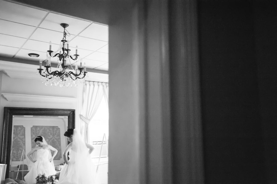 Bride checks herself in the mirror on her wedding day at Snug Harbor, Staten Island. Captured by awesome New York City wedding photographer Ben Lau.