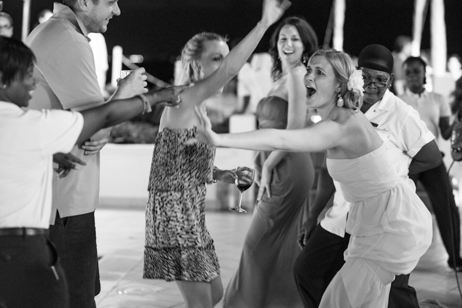 Bride reaches out to guests during her reception at the CuisinArt Resort & Spa in Anguilla. Captured by Caribbean destination wedding photographer Ben Lau.