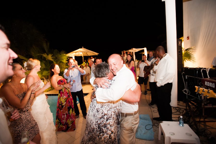 Groom hugs his mom during his reception at the CuisinArt Resort & Spa in Anguilla. Captured by Caribbean destination wedding photographer Ben Lau.