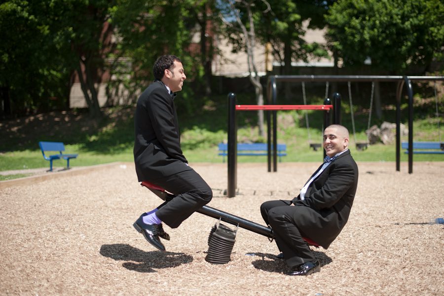 Groom plays with one of his groomsmen on the playground. Captured by awesome NJ wedding photographer Ben Lau.