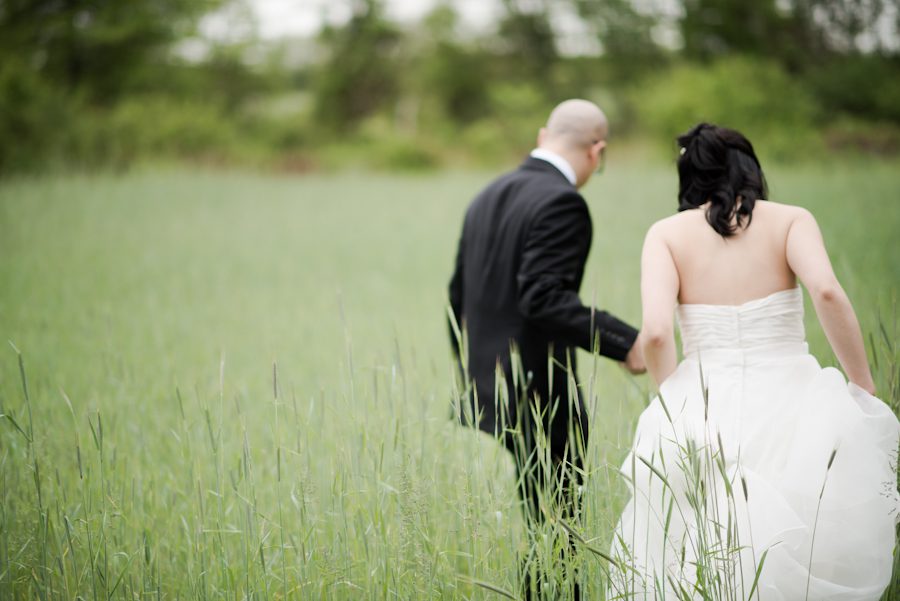 Groom leads his bride into a field of grass on their wedding day in Princeton, NJ. Captured by awesome NJ wedding photographer Ben Lau.