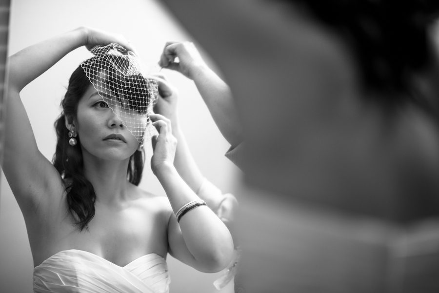 Bride prepares her headpiece on her wedding day at the Mountain Lakes House in Princeton, NJ. Captured by awesome New Jersey wedding photographer Ben Lau.