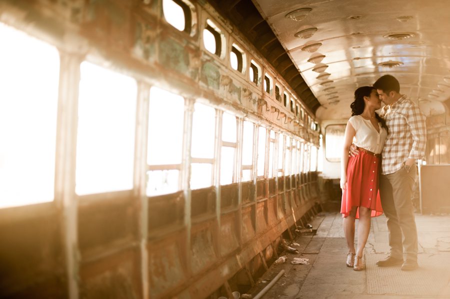 Yumi and Alan pose inside an abandoned train during their engagement session in Red Hook. Captured by awesome NYC wedding photographer Ben Lau.