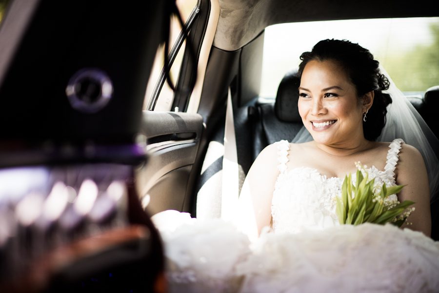 Bride looks out of the window of her limo while en route to her wedding reception at the Oxon Hill Manor in Oxon Hill, MD. Captured by awesome NJ wedding Photographer Ben Lau.