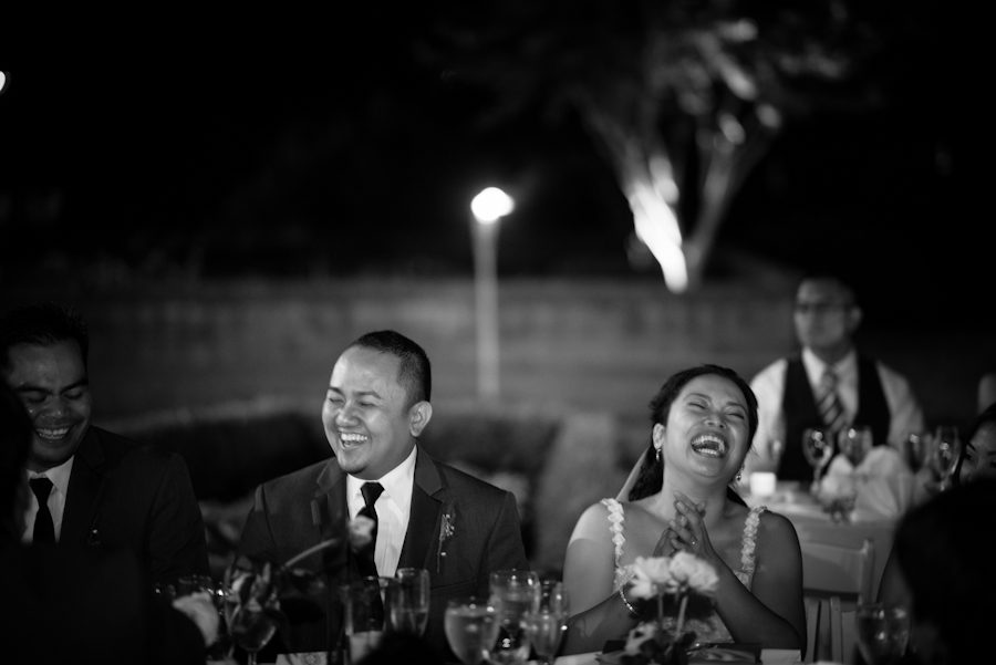 Bride and groom laugh during speeches at their wedding at the Oxon Hill Manor in Oxon Hill, MD. Captured by awesome NJ wedding Photographer Ben Lau.