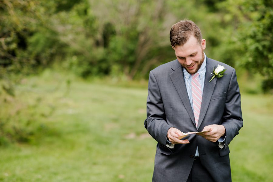 Groom reads a letter from his bride on their wedding day at the Bayard Cutting Arboretum in Long Island, NY. Captured by awesome NJ wedding photographer Ben Lau.
