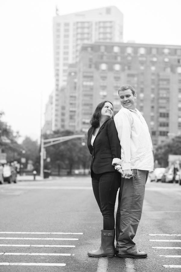 Couple pose on a street during a rainy engagement session in Hoboken, NJ. Captured by awesome NJ wedding photographer Ben Lau.