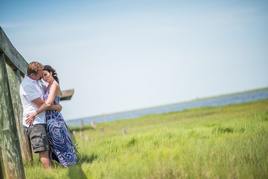 Nicole and Gregg kiss on an old pier in a marsh in Long Beach Island, NJ during their engagement session with Ben Lau Photography.