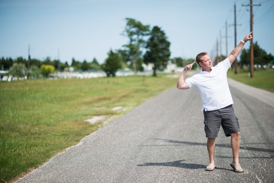 Gregg poses on an empty road in Long Beach Island, NJ during their engagement session with Ben Lau Photography.