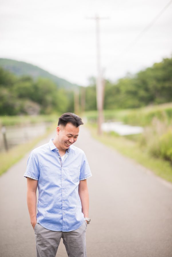 Terence smiles during his pose on an empty road in Bear Mountain, NY. Captured by awesome NJ wedding photographer Ben Lau.