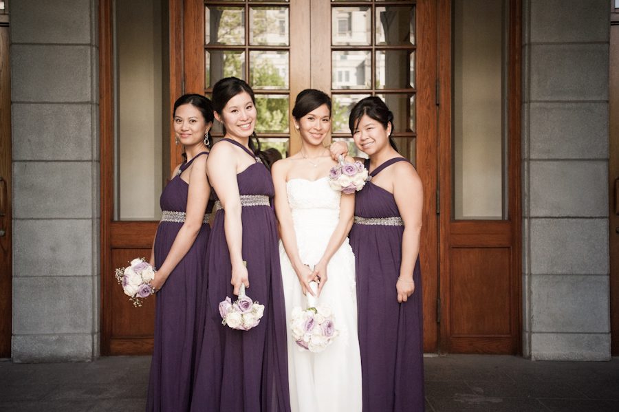 Bridesmaids and bride pose in the front entrance of Le Windsor in Montreal, QC. Captured by destination wedding photographer Ben Lau.