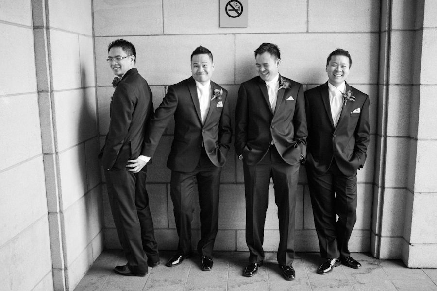 Groomsmen and groom pose in front of Le Windsor in Montreal, QC. Captured by destination wedding photographer Ben Lau.