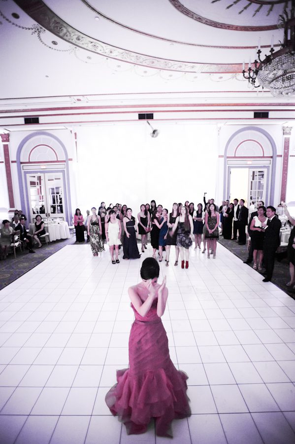 Bouquet toss at a wedding reception at Le Windsor in Montreal, QC. Captured by destination wedding photographer Ben Lau.