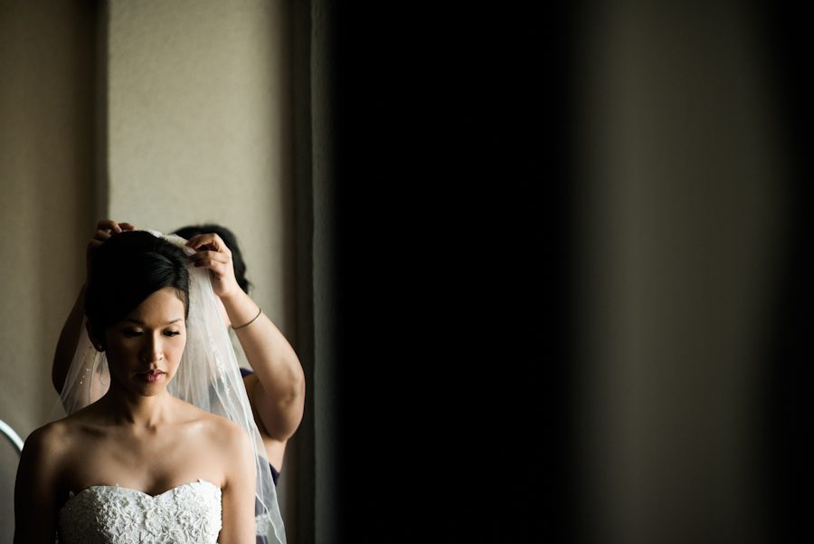 Bride puts on her veil on her wedding day. Captured by Montreal, QC wedding photographer Ben Lau.