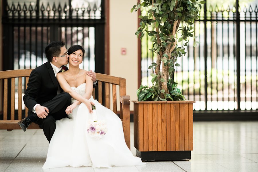 Bride and groom pose on a bench on their wedding day. Captured by Montreal, QC wedding photographer Ben Lau.