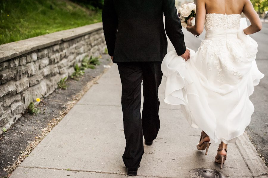 Bride and groom walk on the sidewalk. Captured by Montreal, QC wedding photographer Ben Lau.