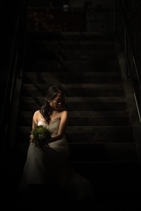 Bride poses on stairs before her wedding at the The Foundry in Long Island City, NY. Captured by NJ wedding photographer Ben Lau.