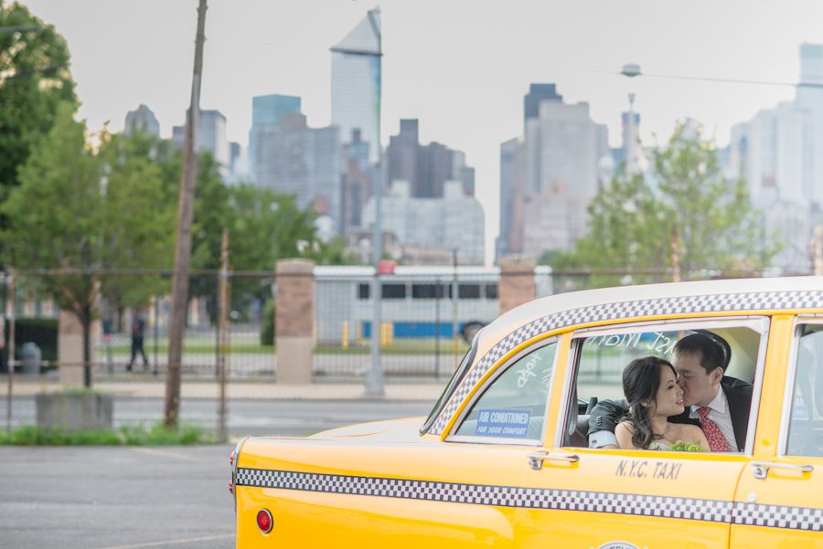 Bride and groom share a kiss inside a vintage taxi outside The Foundry in Long Island City, NY. Captured by NJ wedding photographer Ben Lau.