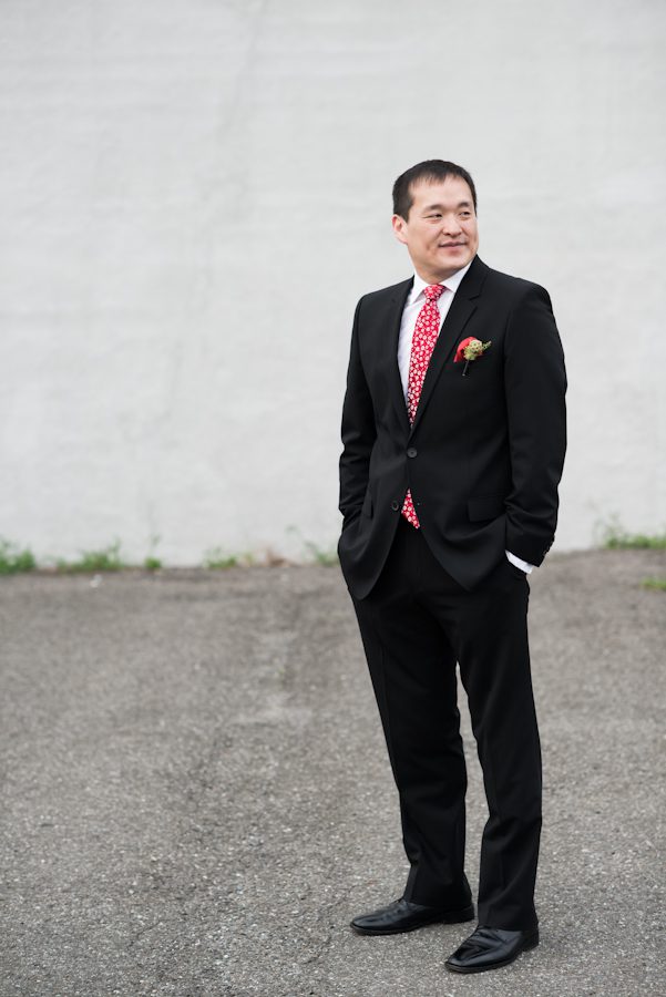 Groom poses for portraits outside The Foundry in Long Island City, NY. Captured by NJ wedding photographer Ben Lau.