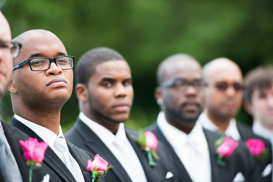 Groomsmen look on during a wedding at the Coral House in Baldwin, NY. Captured by awesome NJ wedding photographer Ben Lau.