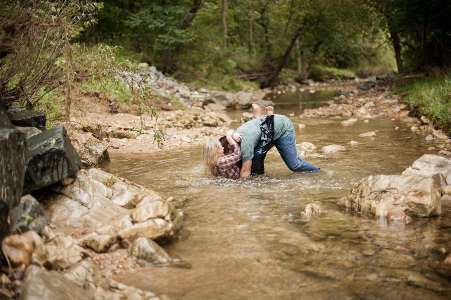 Fran pulls Joe into the creek during their engagement session at the Loch Raven Resevoir in Baltimore, MD with Ben Lau Photography.