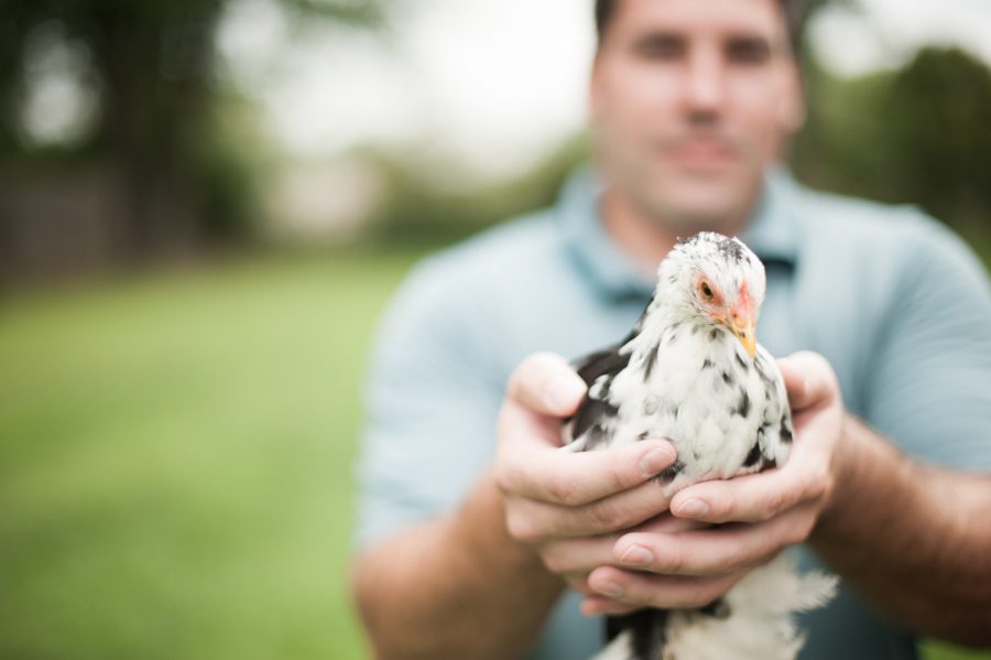 Joe poses with one of his chickens during his engagement session in Baltimore, MD with Ben Lau Photography.