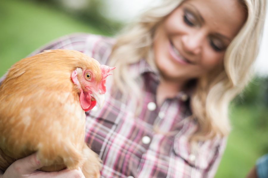 Fran poses with one of her chickens during his engagement session in Baltimore, MD with Ben Lau Photography.