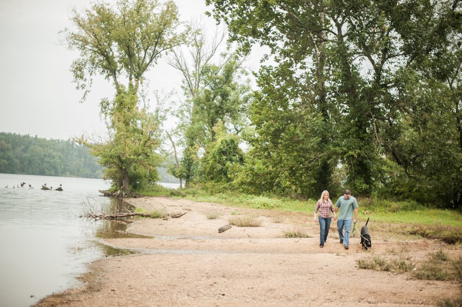 Fran and Joe walk along the water with their dog during their engagement session at the Loch Raven Resevoir in Baltimore, MD with Ben Lau Photography.