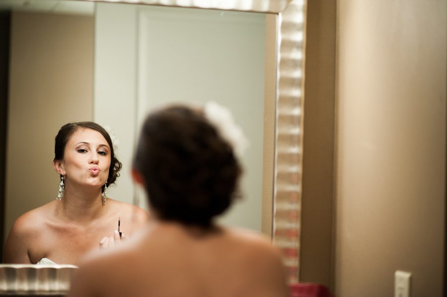 Bride checks her make up in the mirror her wedding day at the Heldrich Hotel in New Brunswick, NJ. Captured by awesome northern NJ wedding photographer Ben Lau.