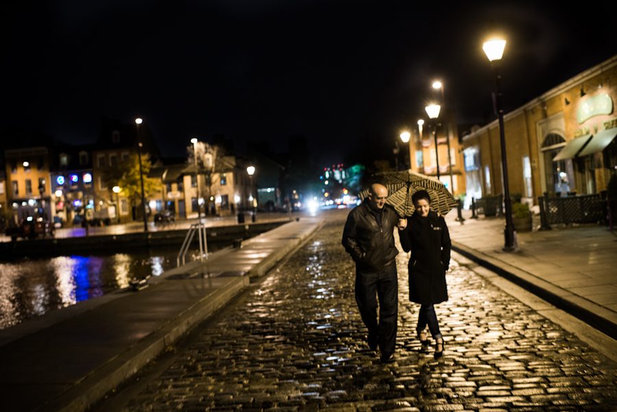 Mary and Adam walk along the cobble stone streets of Fells Point for a rainy evening engagement session.