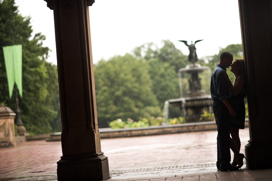 Erin and Tim pose in the archway during her engagement session in Central Park with Ben Lau Photography.
