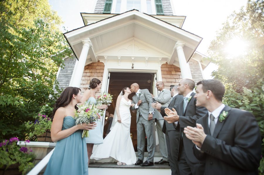Bride and groom share a kiss outside the chapel on their wedding day on Shelter Island, NY. Captured by Northern NJ wedding photographer Ben Lau.