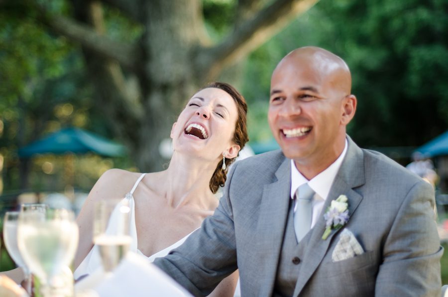 Katie and Jason laugh during speeches during their wedding reception at Ram's Head Inn on Shelter Island, NY. Captured by Northern NJ wedding photographer Ben Lau.