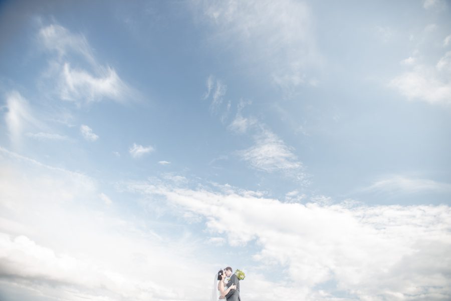 Bride and groom pose for portraits near the Liberty House in Jersey City, NJ. Captured by northern nj wedding photographer Ben Lau.