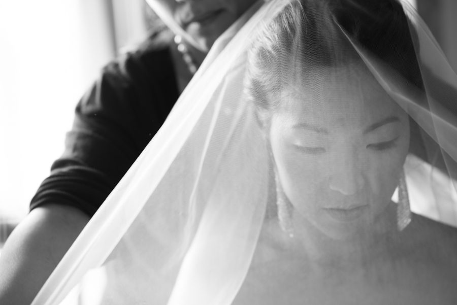 Bride Sarah puts on her veil on her wedding day at The Manor in West Orange, NJ. Captured by northern nj wedding photographer Ben Lau.