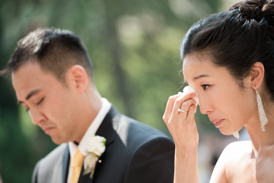 Bride cries during her outdoor wedding ceremony at The Manor in West Orange, NJ. Captured by northern NJ wedding photographer Ben Lau.