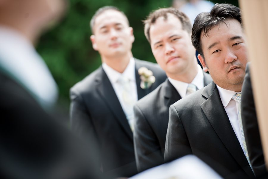Groomsman looks on during an outdoor wedding ceremony at The Manor in West Orange, NJ. Captured by northern NJ wedding photographer Ben Lau.