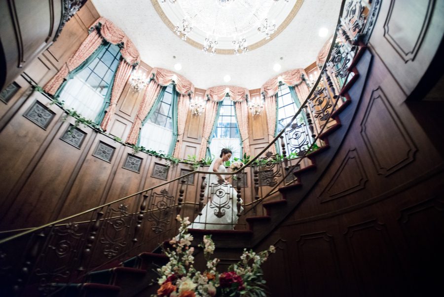 Bride ascends the stairs at The Manor in West Orange, NJ. Captured by northern NJ wedding photographer Ben Lau.