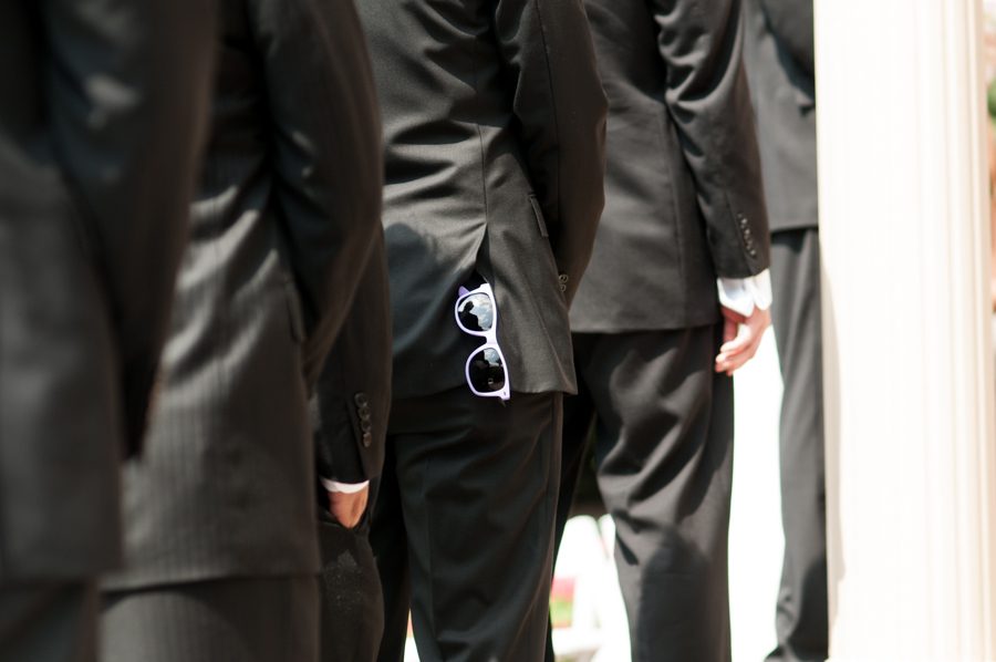 Groomsmen stores away his sunglasses during a wedding at The Manor in West Orange, NJ. Captured by northern NJ wedding photographer Ben Lau.