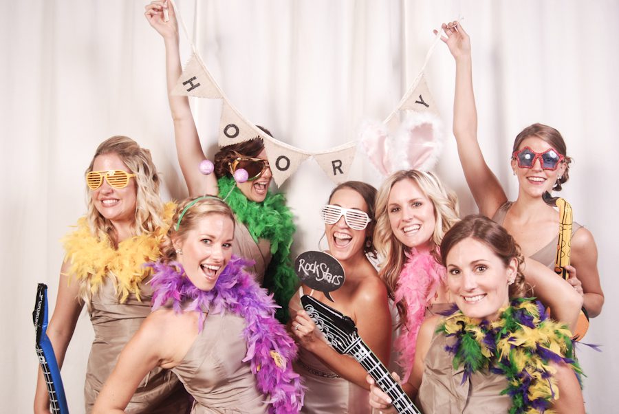 Guests pose at a photo booth at a wedding reception at the Baltimore Museum of Industry in Baltimore, MD. Captured by northern NJ wedding photographer Ben Lau.