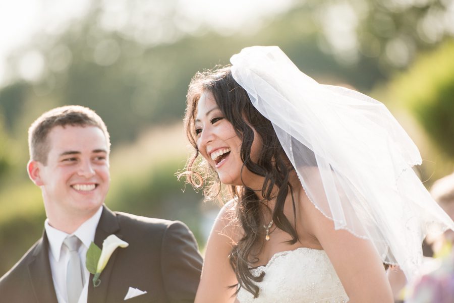 Bride laughs during her wedding at the Neshanic Valley Golf Course in Neshanic Station, NJ. Captured by northern NJ wedding photographer Ben Lau.