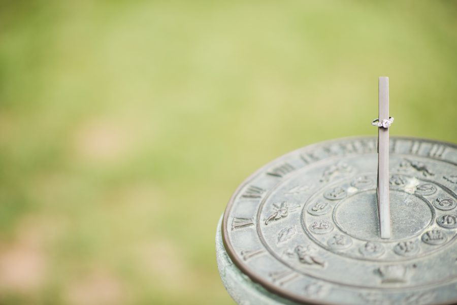 Rings on a sundial during an engagement session at the NJ Botanical Gardens. Captured by northern NJ wedding photographer Ben Lau.