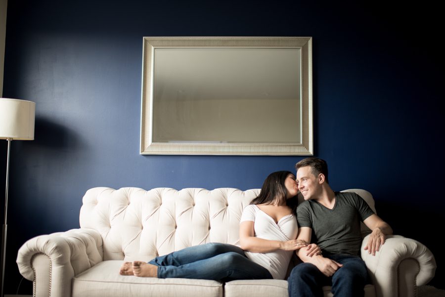 Amedea and Ray cozy up on their couch during their indoor engagement session with NYC wedding photographer Ben Lau.