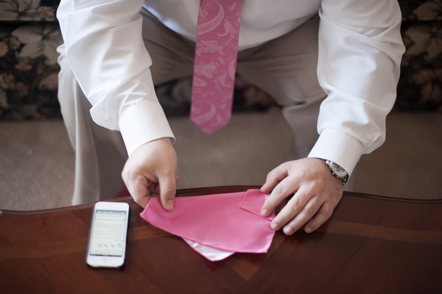 Groomsmen folding pocket square on the morning of Joe and Fran's wedding at the Baltimore Yacht Club. Captured by Baltimore wedding photographer Ben Lau.