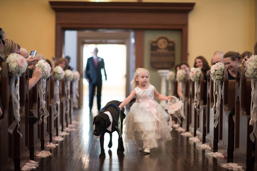 Flower girl and ring-dog during procession at Joe and Fran's wedding at Notre Dame of Maryland. Captured by Baltimore wedding photographer Ben Lau.